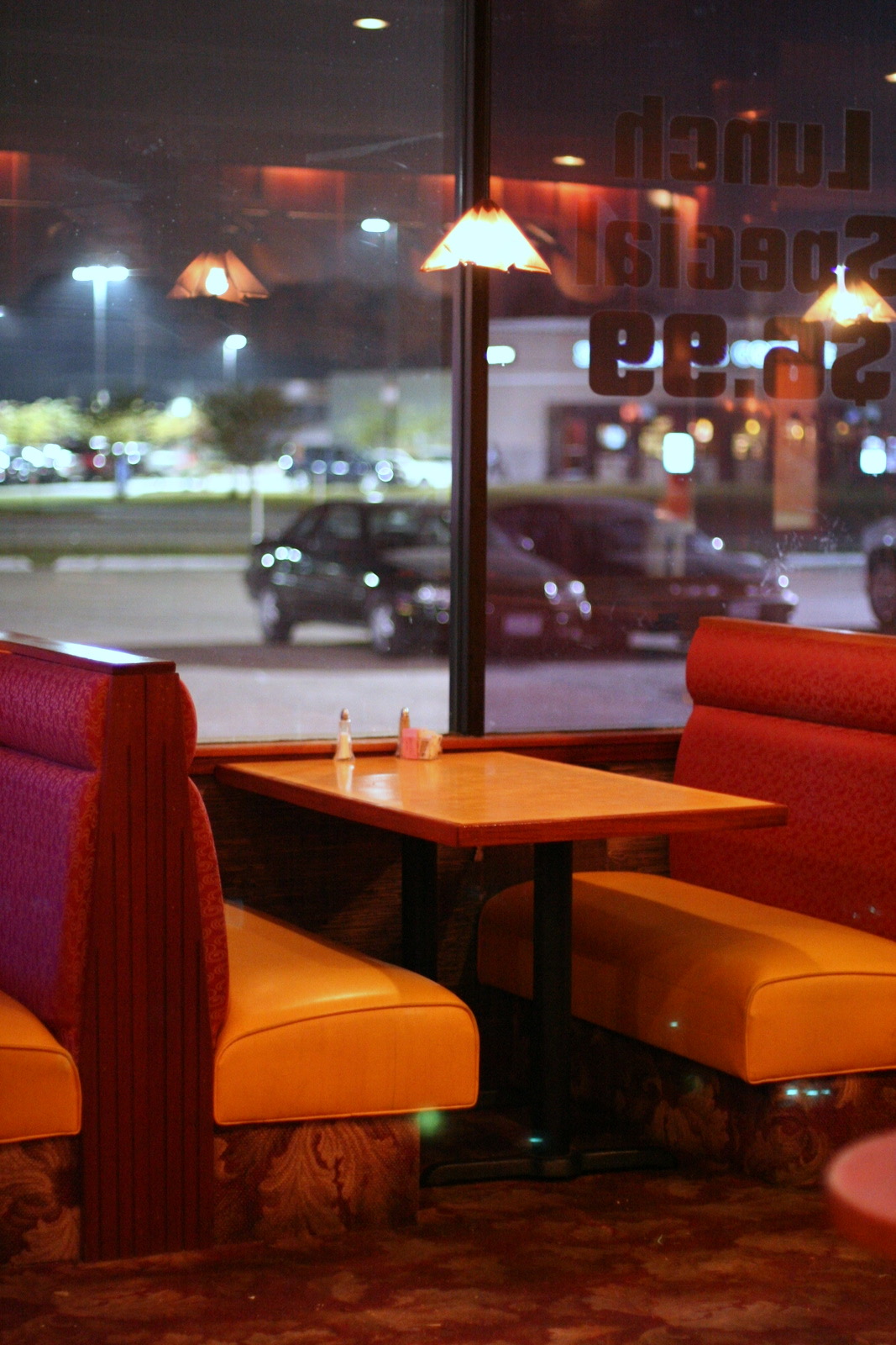 Upholstered restaurant dining booth beside a wooden table