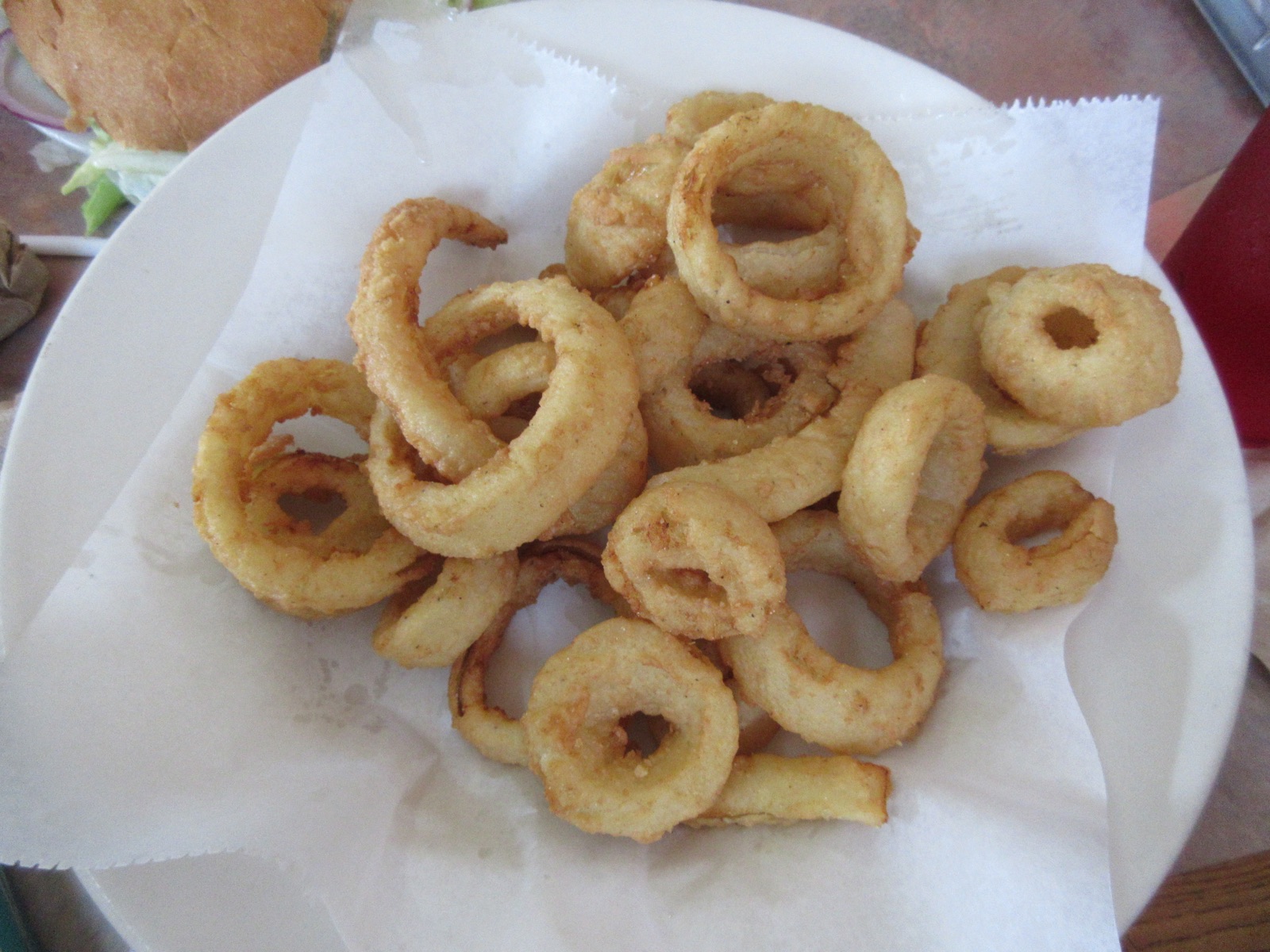 Basket of crisp onion rings on paper at a diner